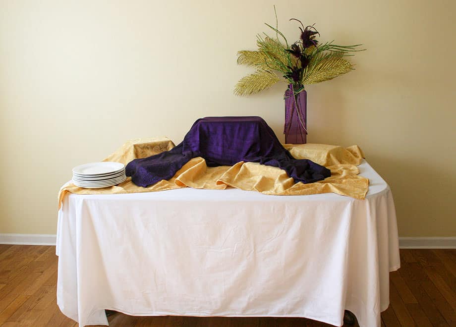 Table with gold and purple tablecloths and purple vase