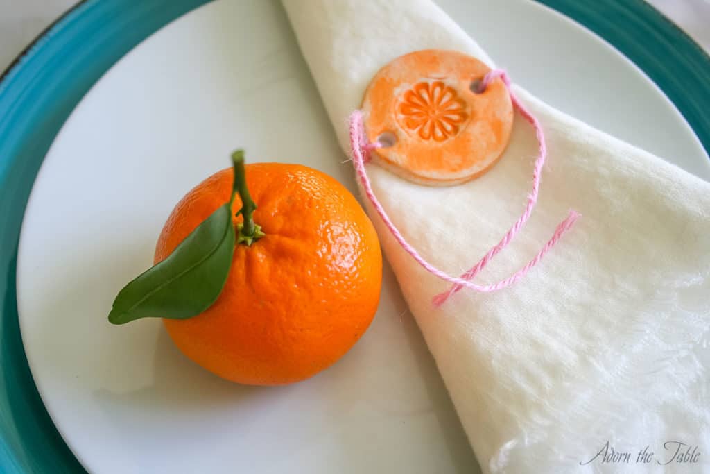 Mother's day place setting. Close up on diy linen napkin and orange diy napkin ring.