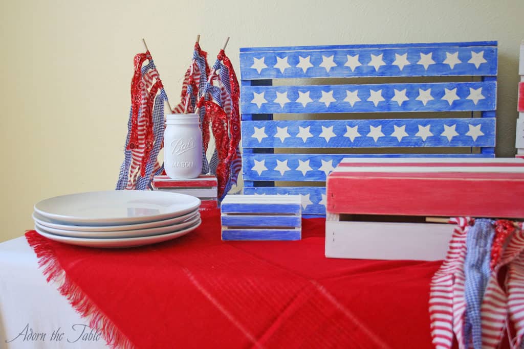 straight view of wooden crates and ripped fabric flags in mason jar on the left side of the table