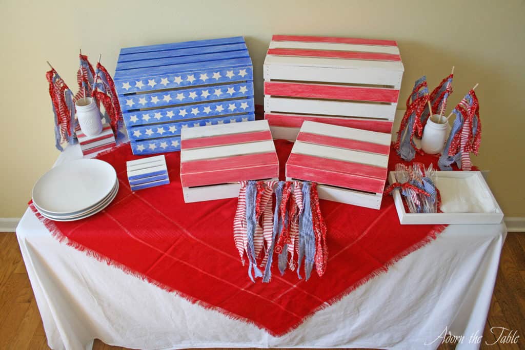 memorial day buffet table complete with red scarf, diy wooden craft crates and ripped fabric flags. All in red, white and blue.