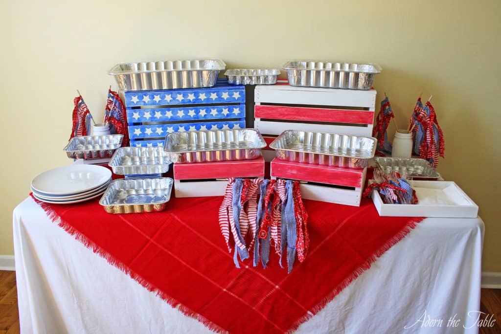 Memorial day buffet table with food trays. front view. everything is red, white and blue