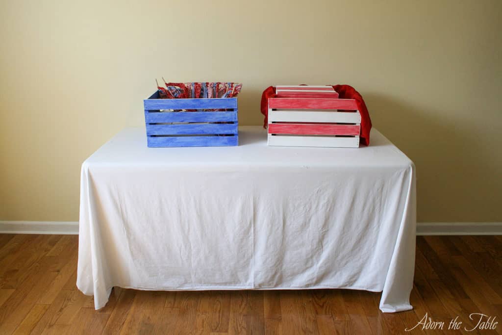Folding table with white sheet and DIY painted wooden crate