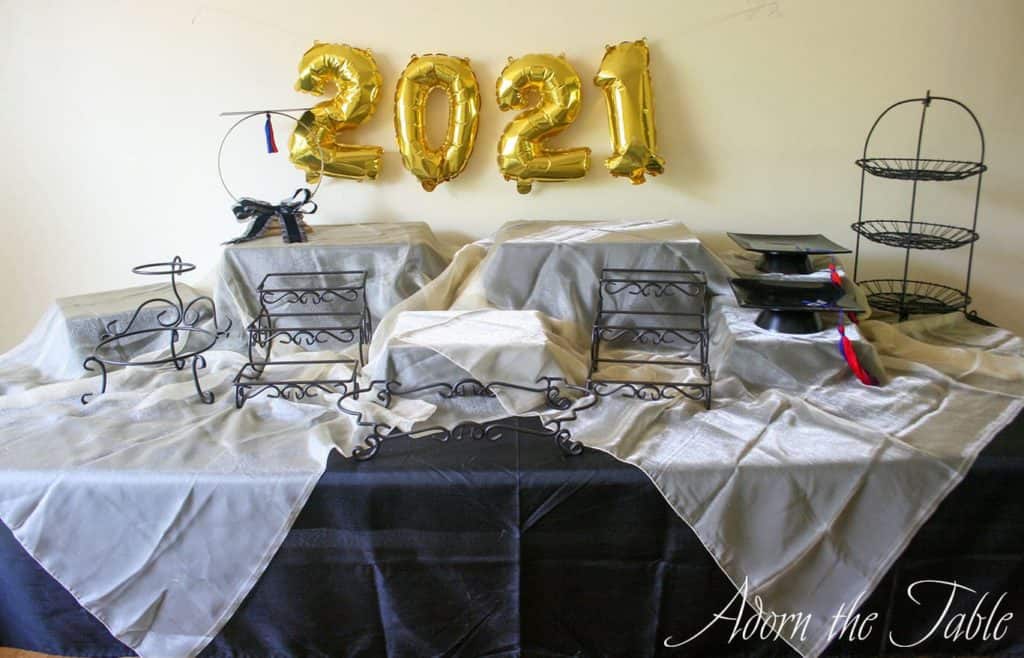 Graduation-Buffet-Table-black tablecloth, gold accent layer and graduation centerpiece-centerview