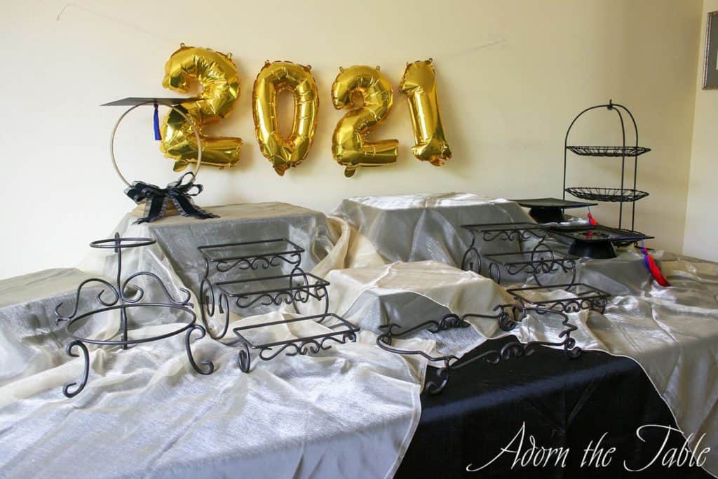 Graduation-Buffet-Table-black tablecloth, gold accent layer and graduation centerpiece-center