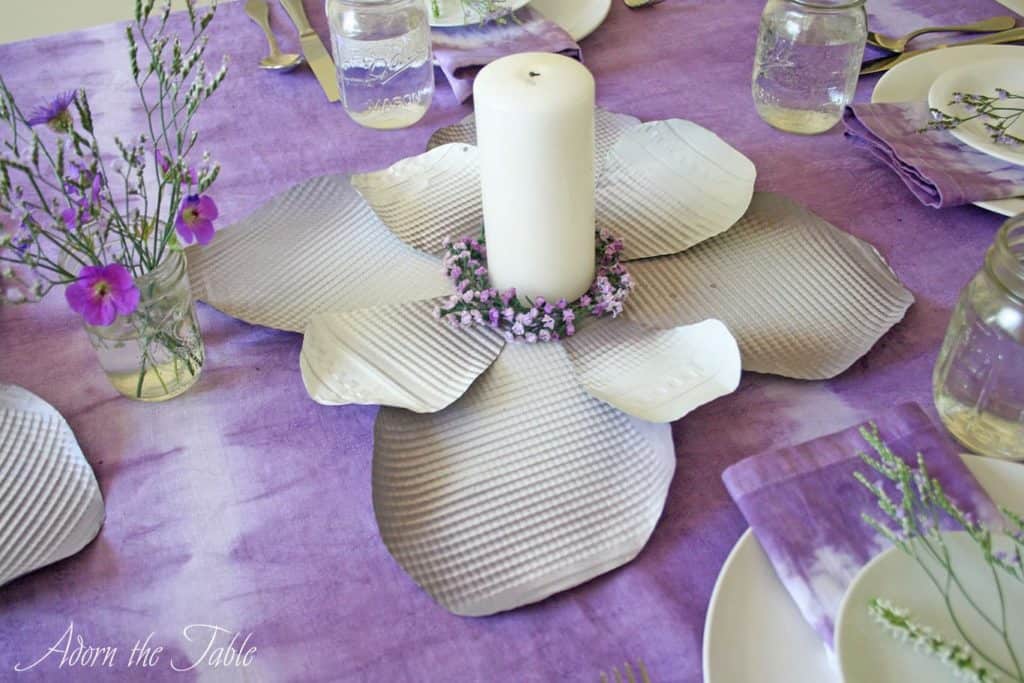 Metal flower centerpiece on lilac tie-dyed tablecloth