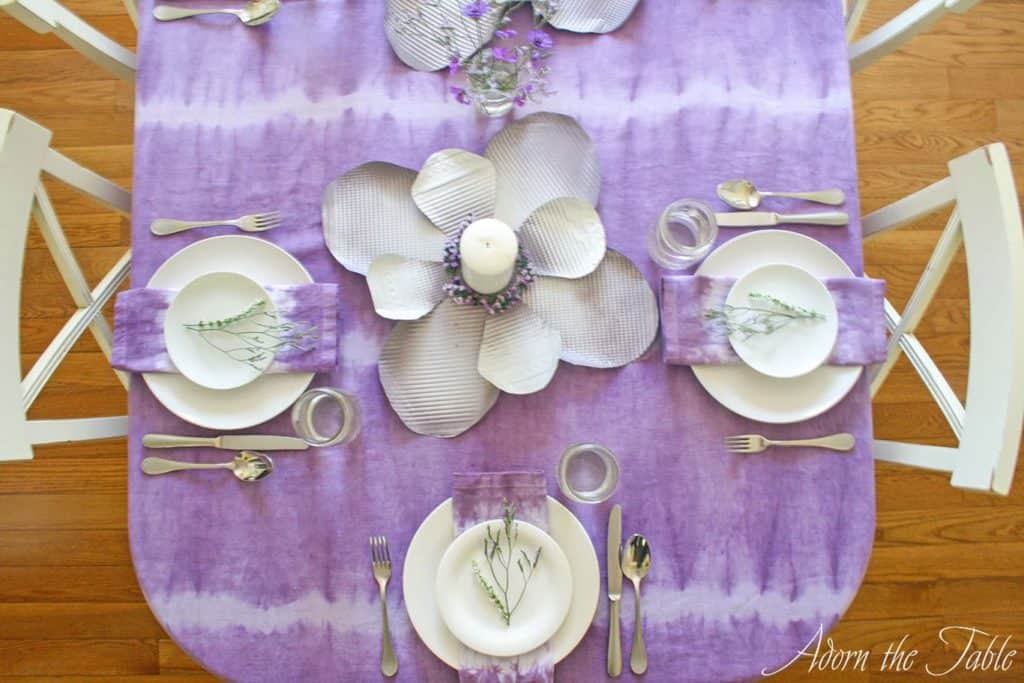 Overhead view of the foot of the lilac and white tablescape