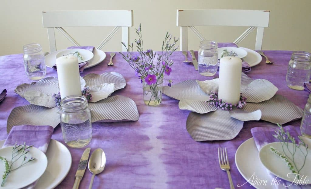 Middle view of boho table setting with metal diy flowers and tie-dyed tablecloth.