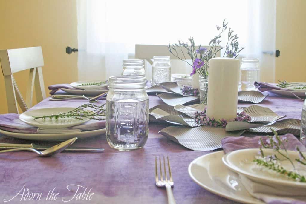 View of mason jar on lilac tie-dyed tablecloth
