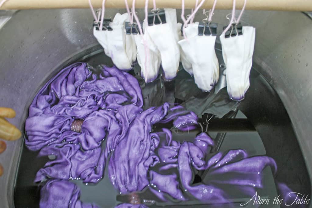 Tablecloth and napkins submerged in dyebath.