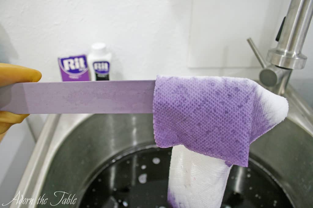 Paper towel dipped in dyebath showing lilac dye color.