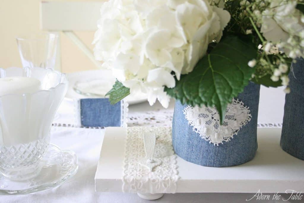 DIY white wooden serving tray with denim and lace vases that are holding white flowers.