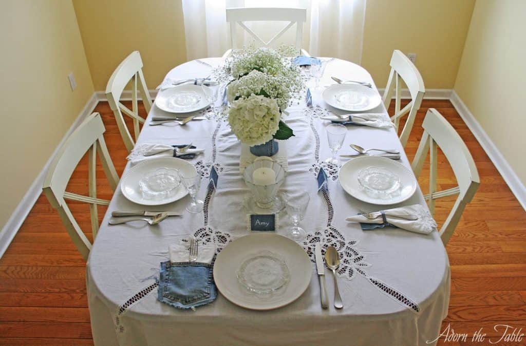 Denim and white lace table setting. View from the head of the table.