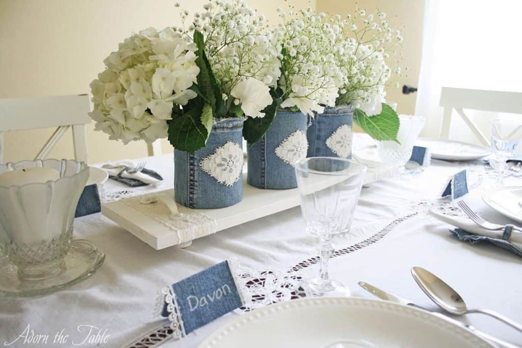 Denim and white lace centerpiece with white wood serving tray and denim covered vases. 