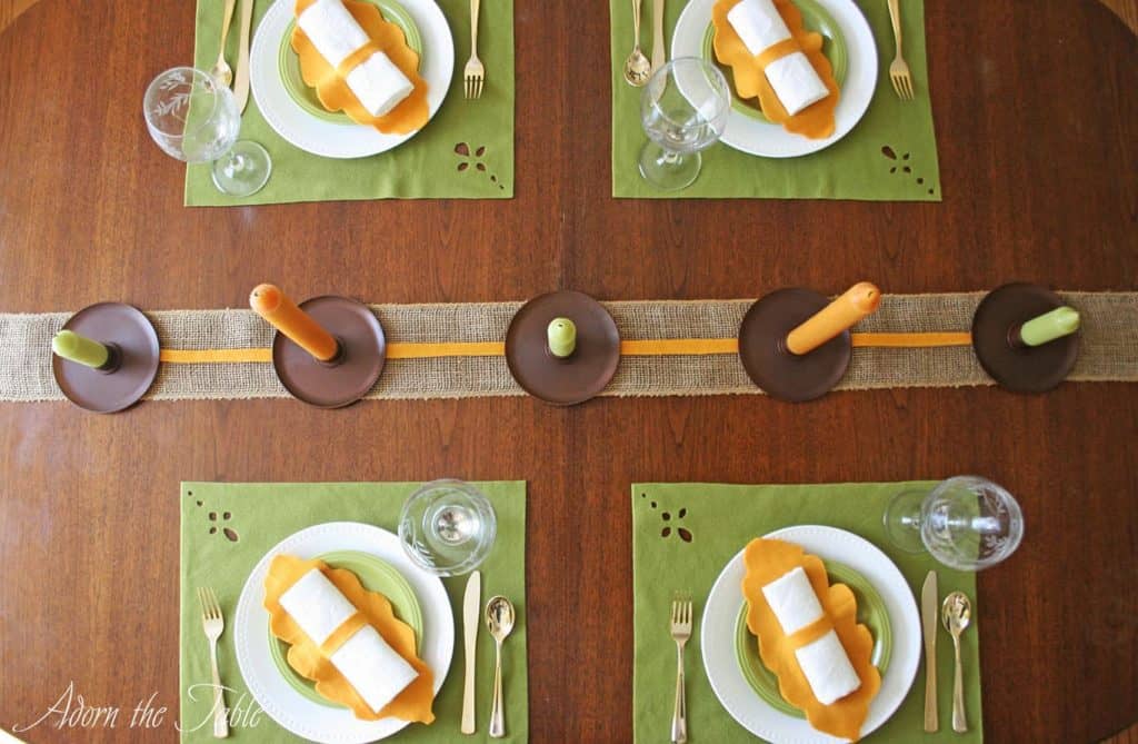 Overhead view of green and orange fall-inspired table setting.