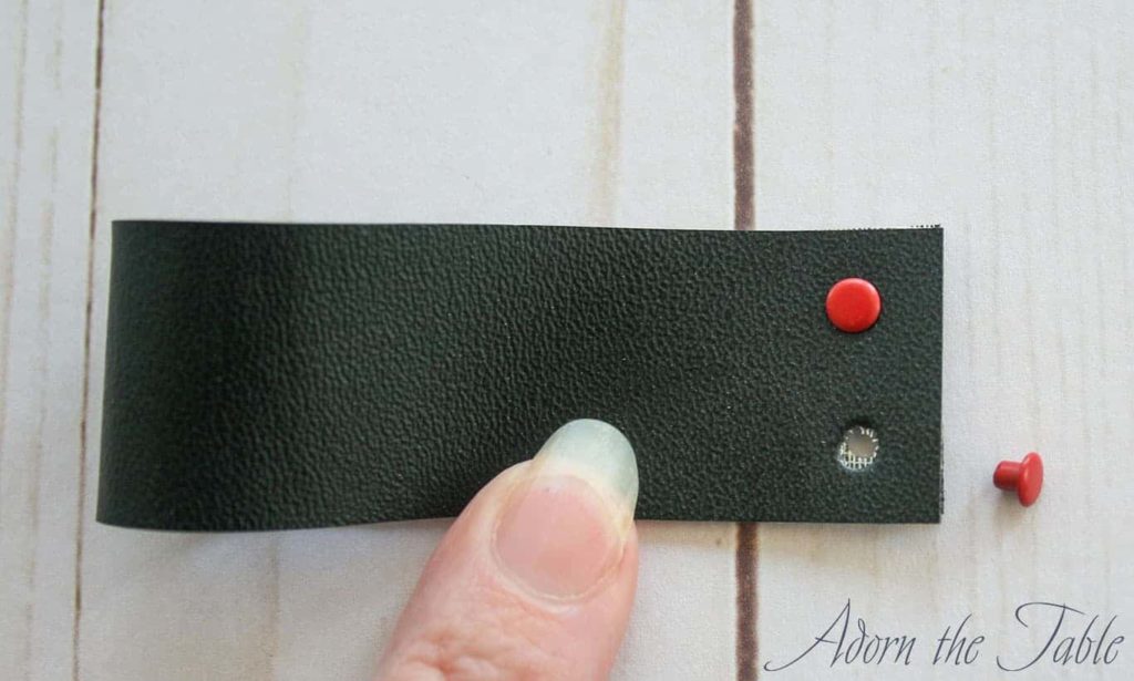 Push one eyelet through a punched hole in the napkin ring strip.