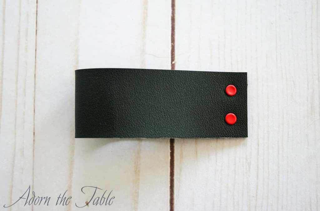 Final faux leather diy napkin ring. Black with red eyelets.