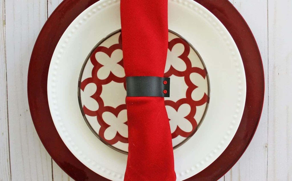Black DIY faux leather napkin ring around red napkin.