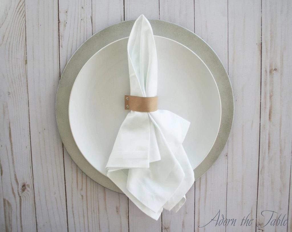 Faux leather napkin ring on white plate.