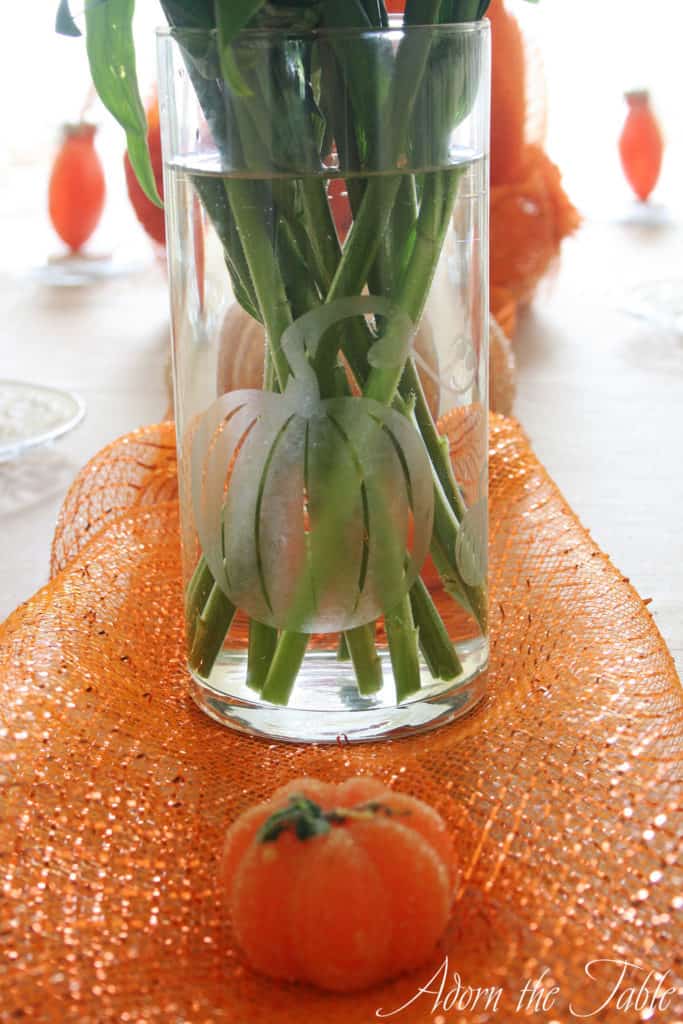 Pumpkin glass vase for autumn table setting on orange mesh