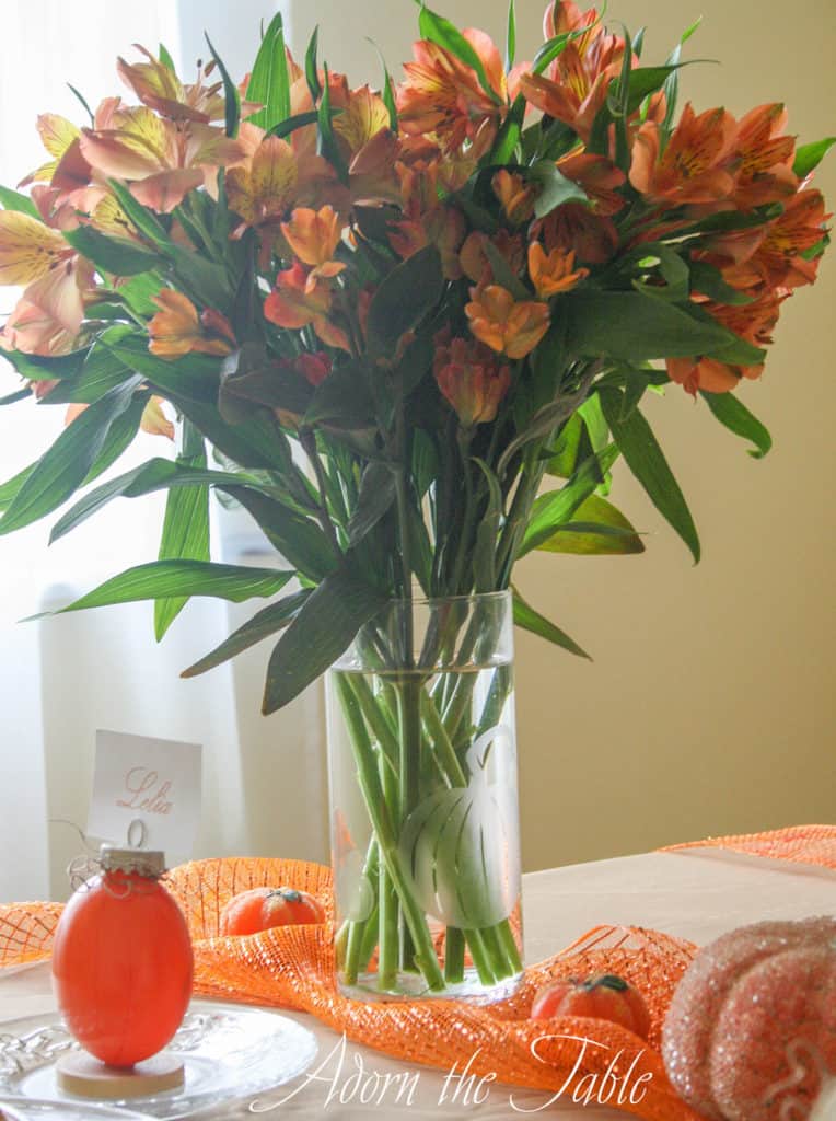 Pumpkin glass vase for autumn table setting on orange mesh