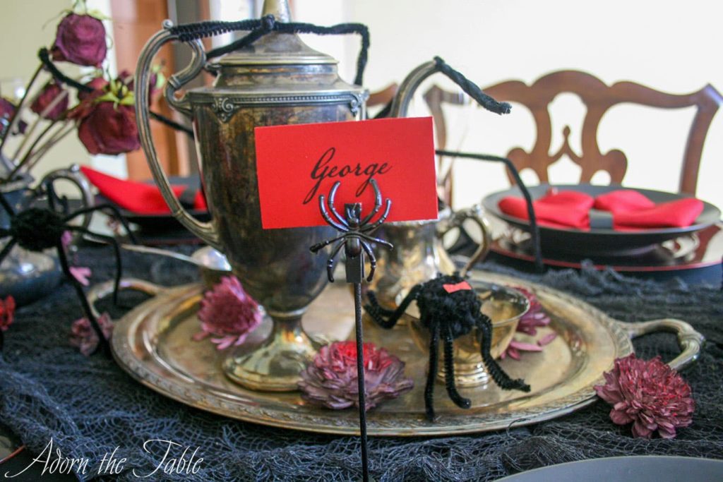 Red name card on black spider place card holder.