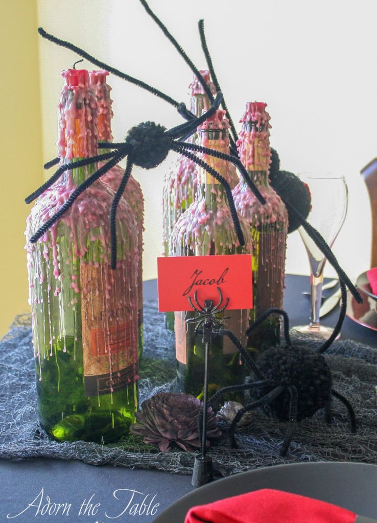 Spiders crawling on wax dripped wine bottles