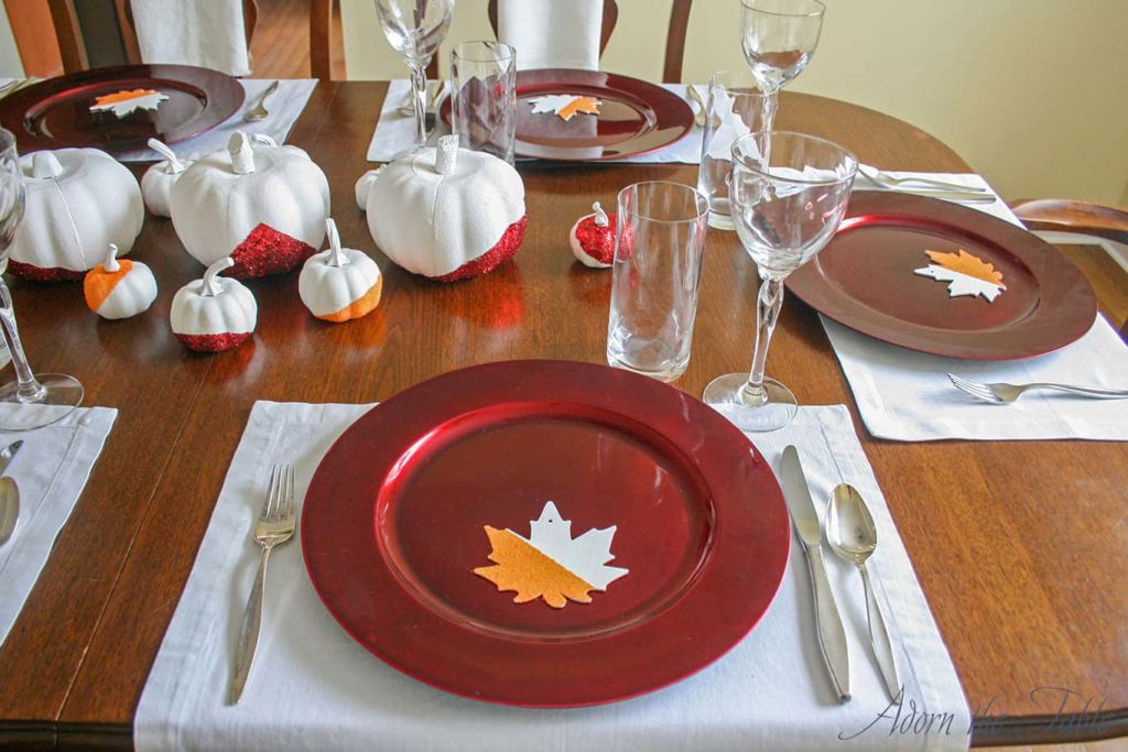 Simple Thanksgiving day place setting red charger and silver flatware.