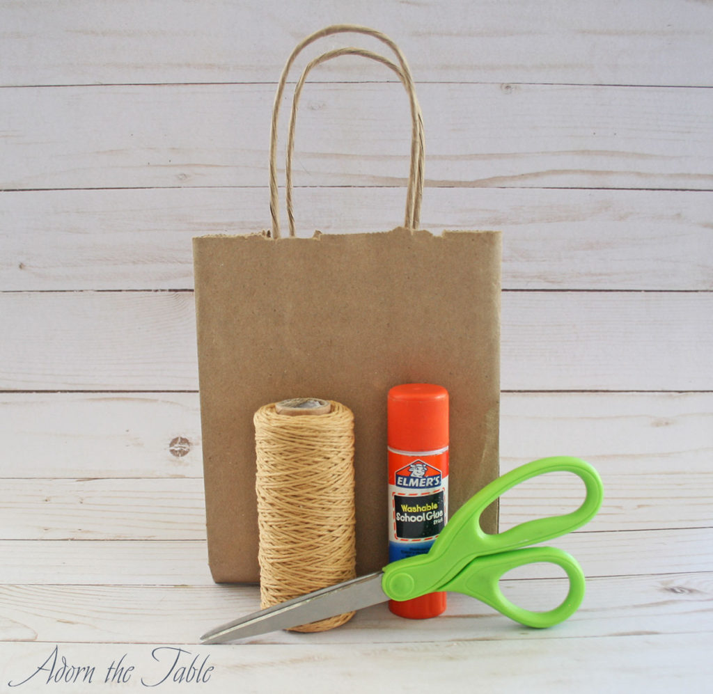 Halloween diy trick or treat paper bag supplies: paper bag, twine, glue and scissors.