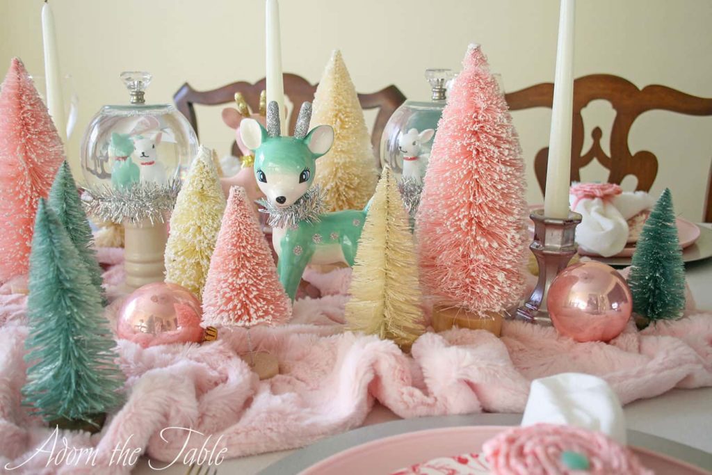 Retro Christmas table setting with pink and cream trees and teal reindeer as centerpiece