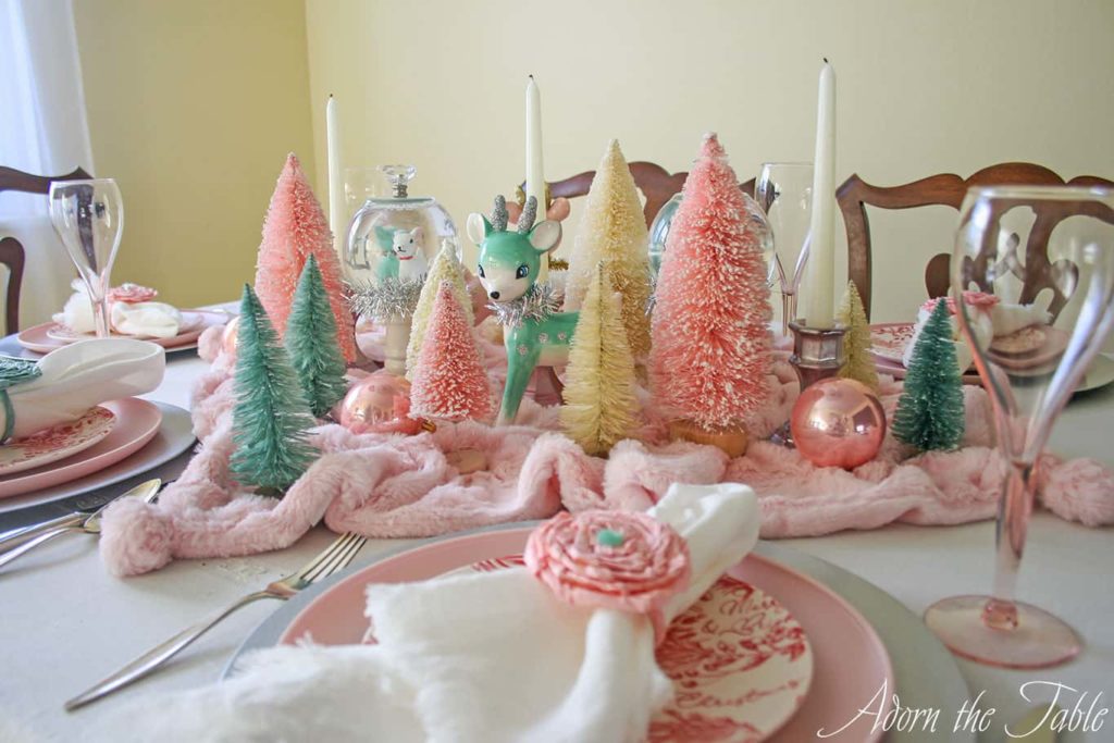 Vintage Christmas table setting featuring bottle brush trees and large reindeer.