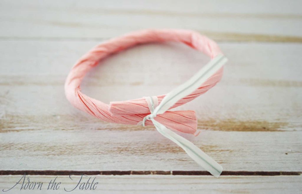 Pink twisted paper cord with twisted tie securing it