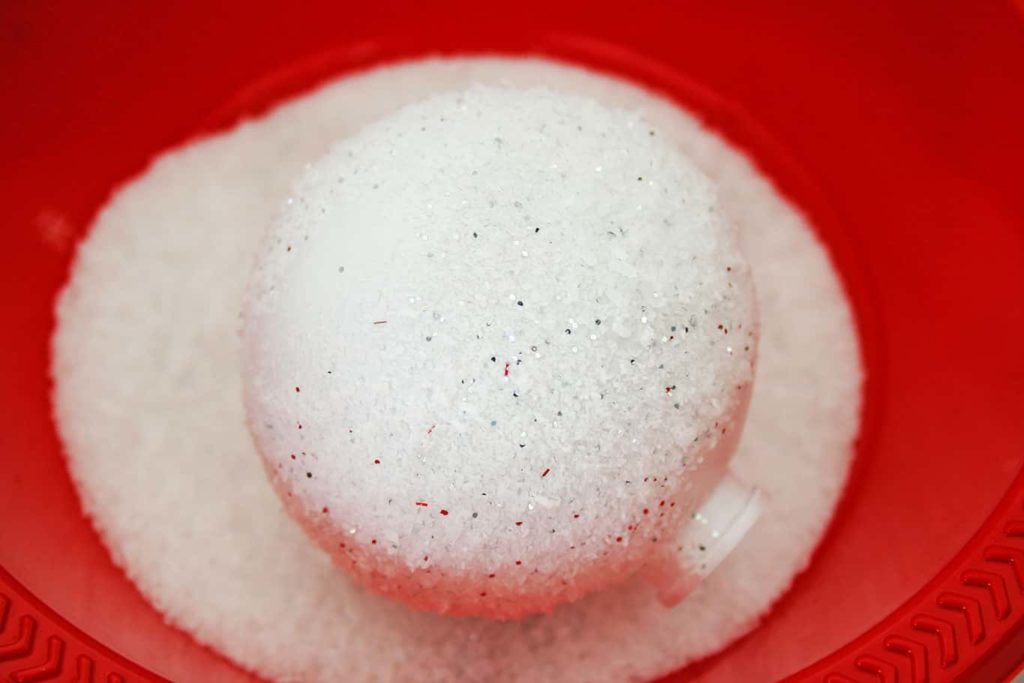 Ornament covered in fake snow in bowl