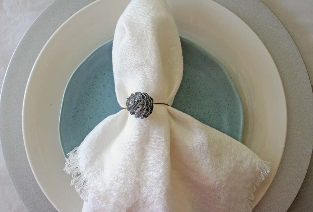 Place setting with pinecone napkin ring