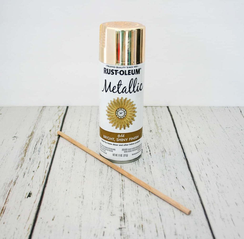 Gold spray paint and wooden dowel.