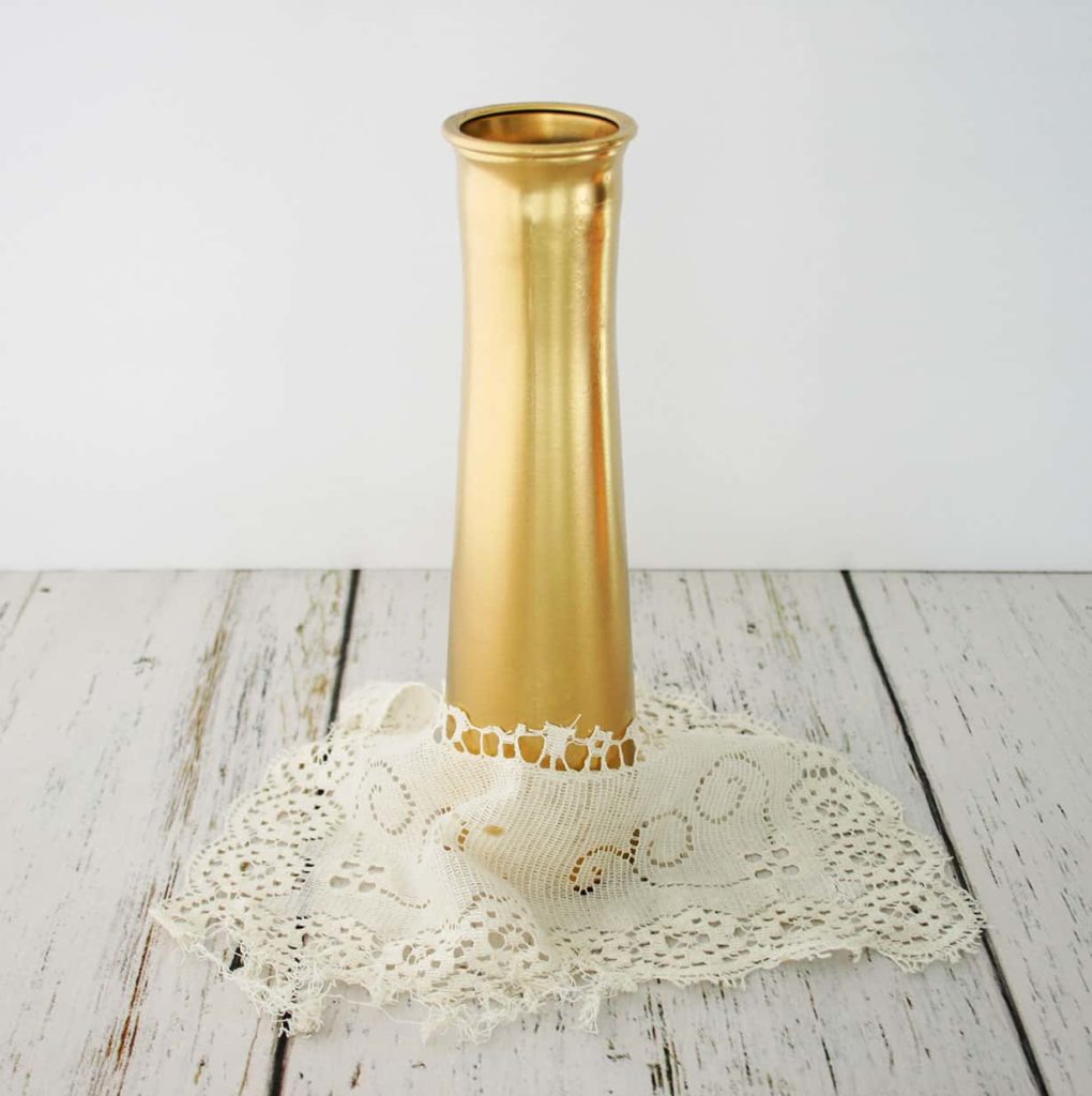 Lace in front of gold vase
