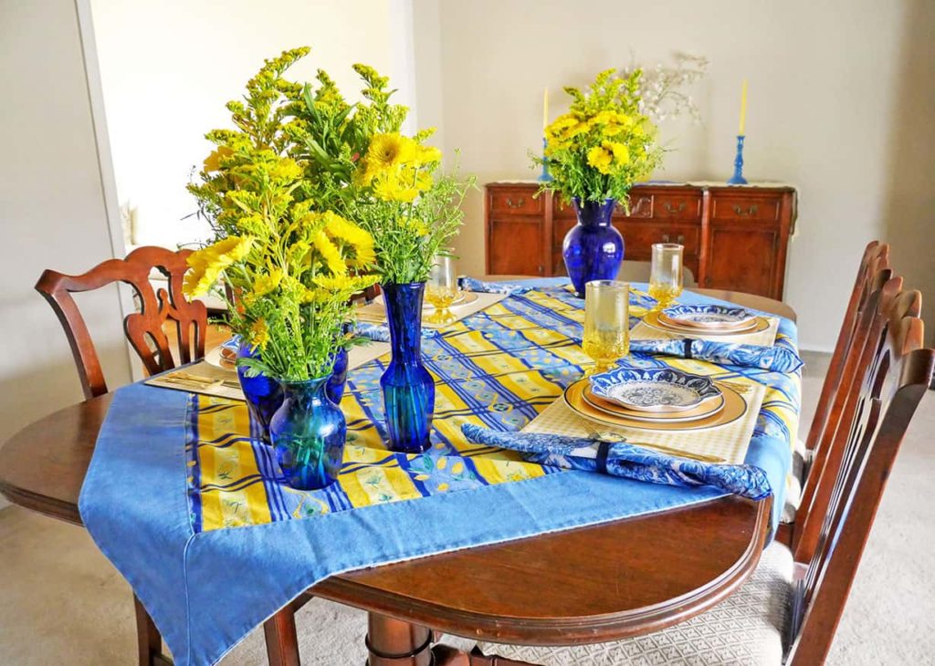 Blue and yellow tablescape for Spring with sideboard in the background.