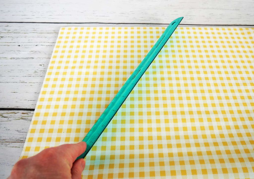 Ruler smoothing out bubbles in wallpaper