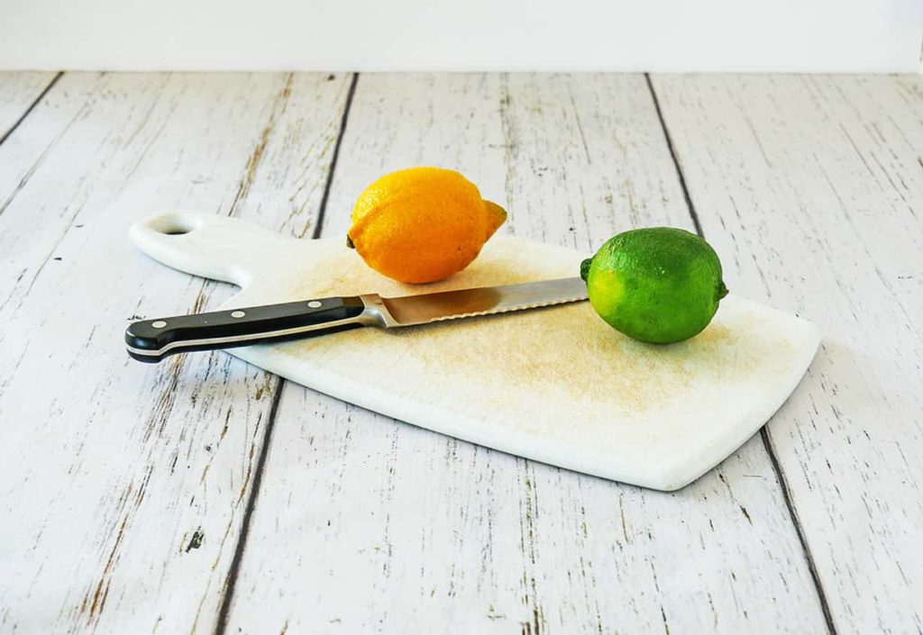 Lemon and lime on cutting board