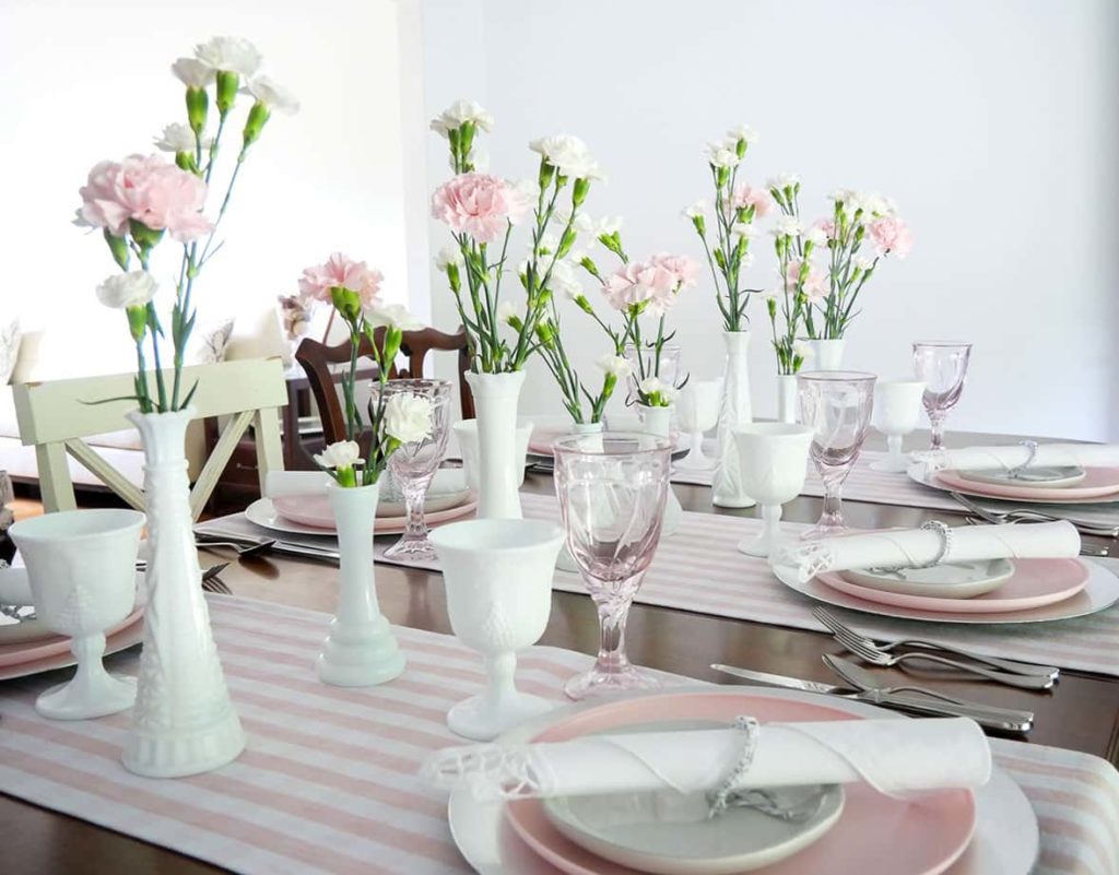 White vases with pink and white flowers on table