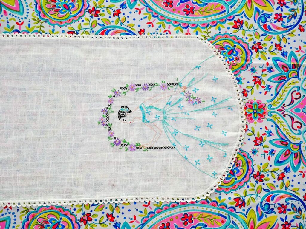 Embroidered dresser scarf on tablecloth