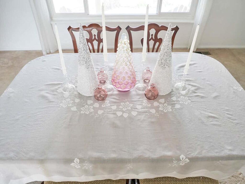 Candle sticks and vases added to pretty Christmas table setting