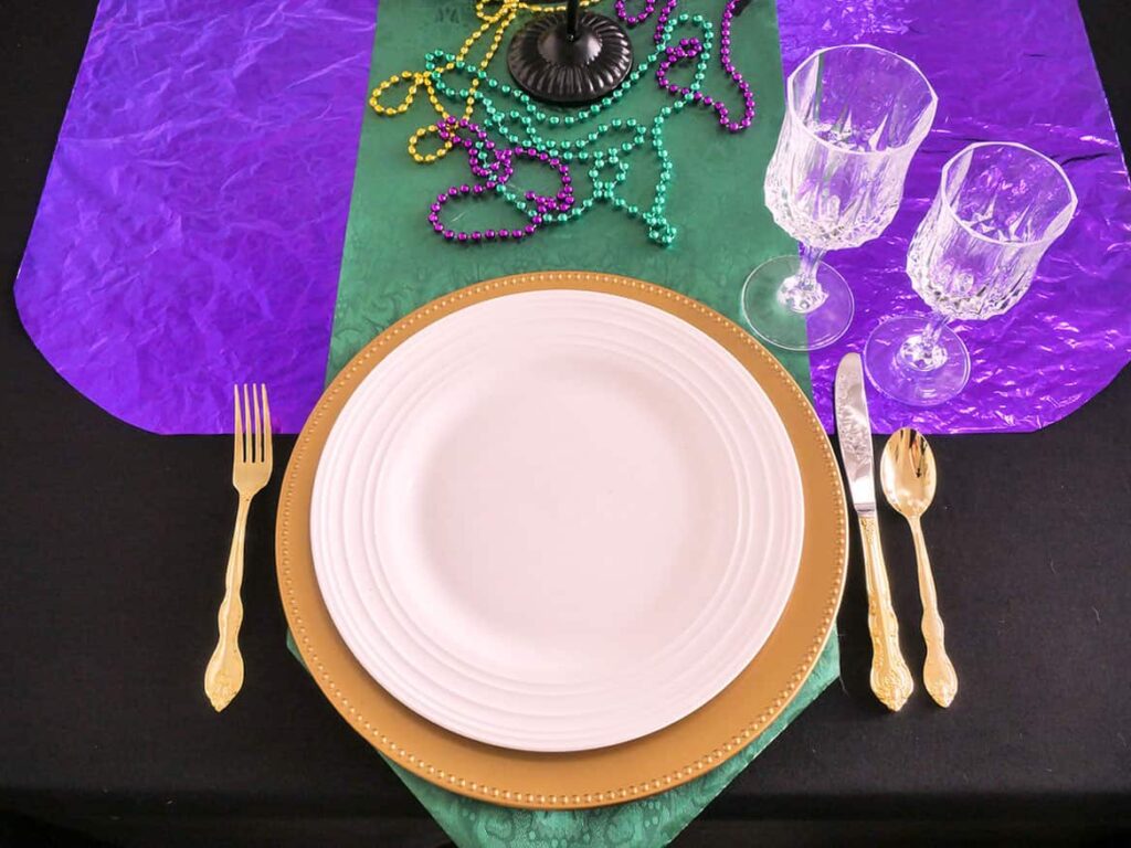 Gold flatware and wine glasses added to Budget Mardi Gras Tablescape