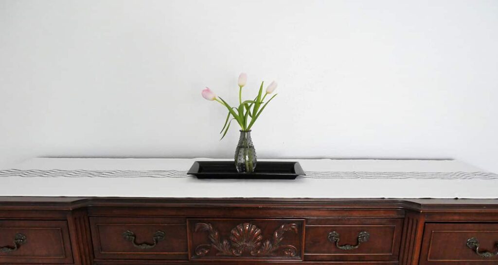 Buffet centerpiece of smoky vase holding three tulips.