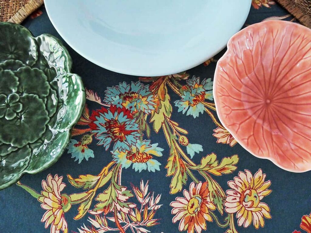 Three different colored plates with floral tablecloth