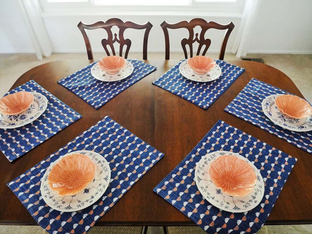 Salmon colored bowls on top of the plates.