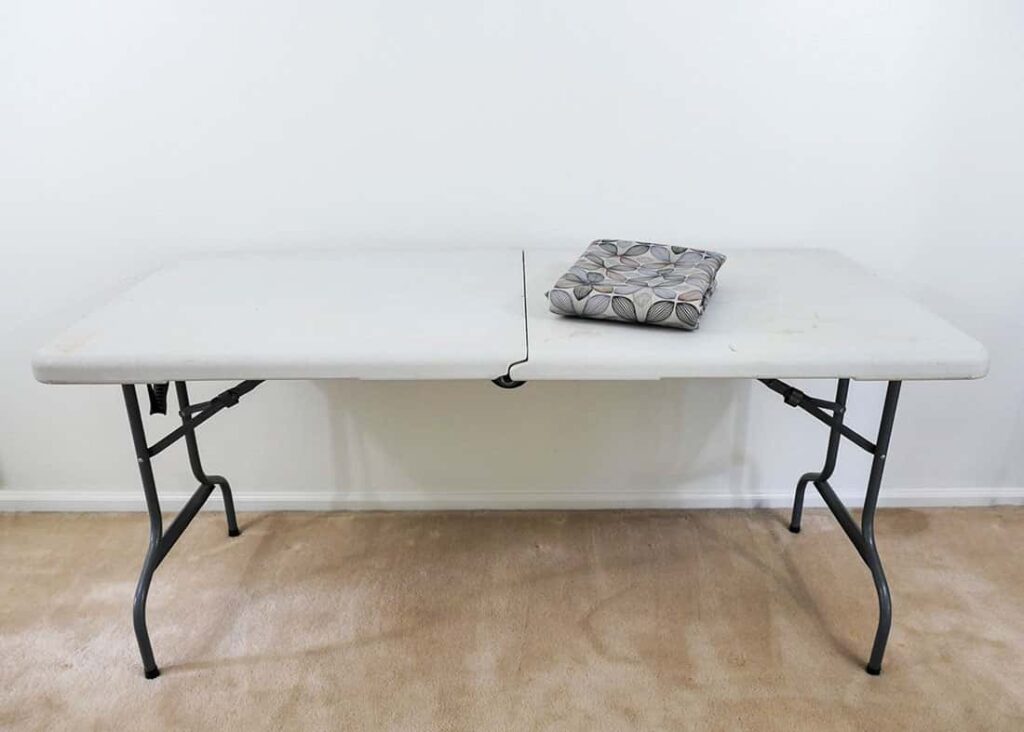 Folding table with tablecloth folded on top