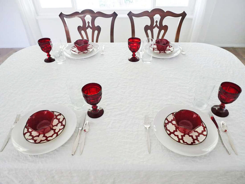 Clear water glasses and red goblets on apple harvest Fall tablescape.