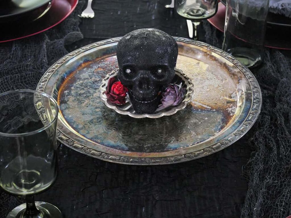 Close up of black skull with red flowers.
