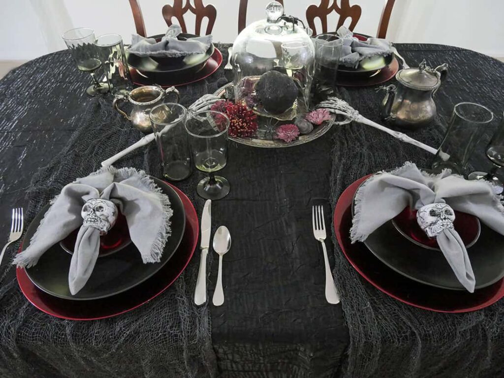 Skeleton hands and silver bowls added to spooky Halloween skeleton centerpiece.