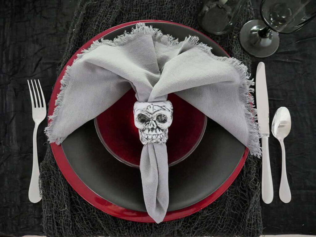 Overhead view of diy skull napkin rings on Halloween place setting.